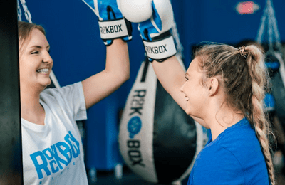 Two happy RockBox members congratulating each other during a kickboxing workout